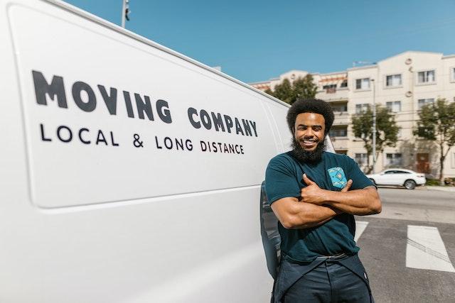 A man standing beside a white moving van