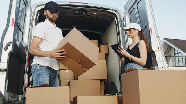 Woman and man organizing boxes in the van