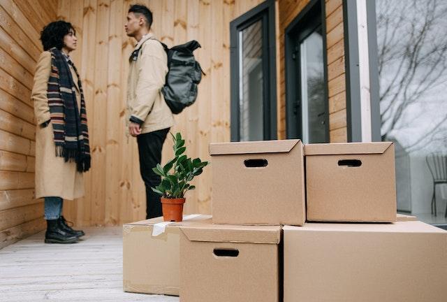 man and woman having a conversation while standing near packed moving boxes