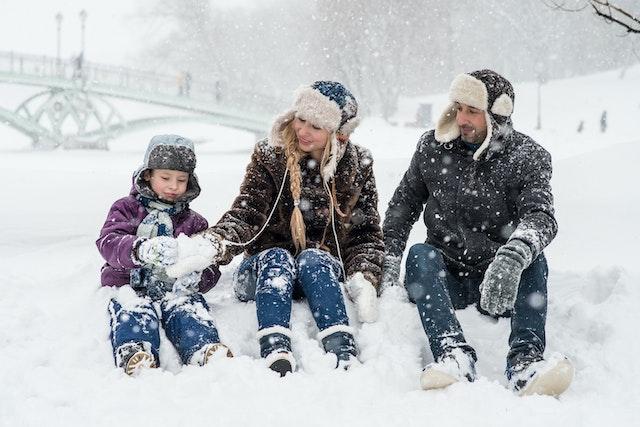 Parents with their child sitting in the snow