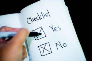 Close-up of a hand ticking off “No” on a checklist with a black marker, highlighting decision-making
