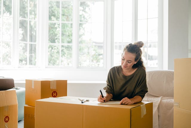 Woman writing answers to questions to ask yourself before moving