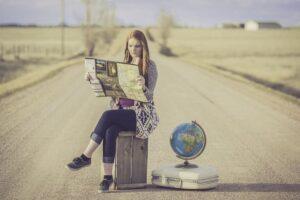 A woman with a map and a suitcase is getting ready to plan a stress-free international relocation