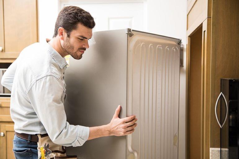 A man is moving a refrigerator