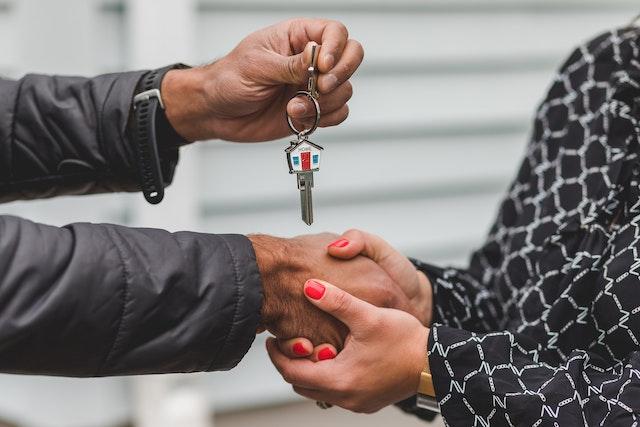 People shaking hands and exchanging a house key