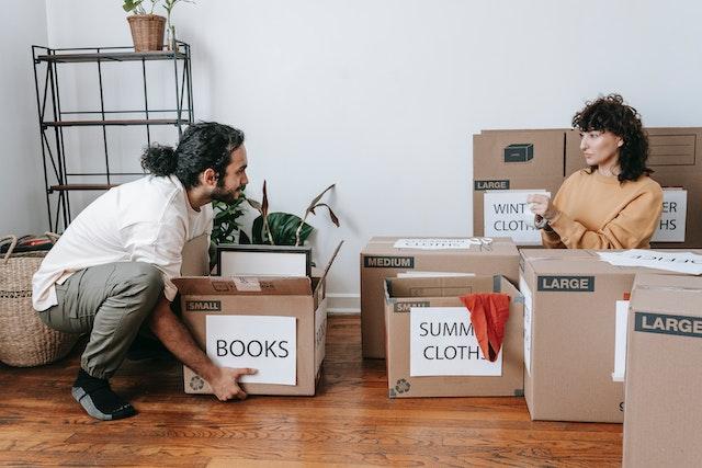 Couple labeling moving boxes